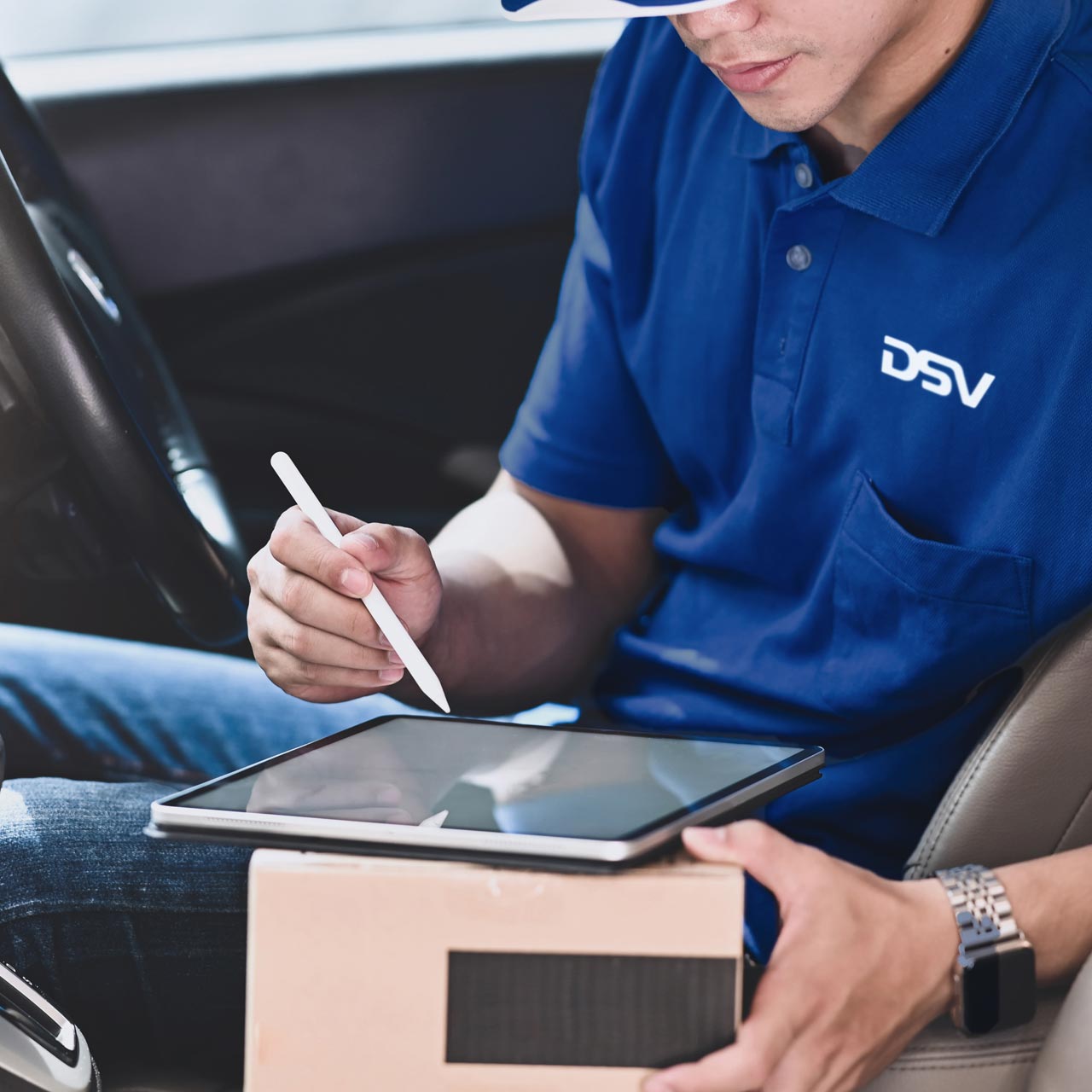 Modern delivery -Driver using mobile phone to manage packages in a delivery truck.